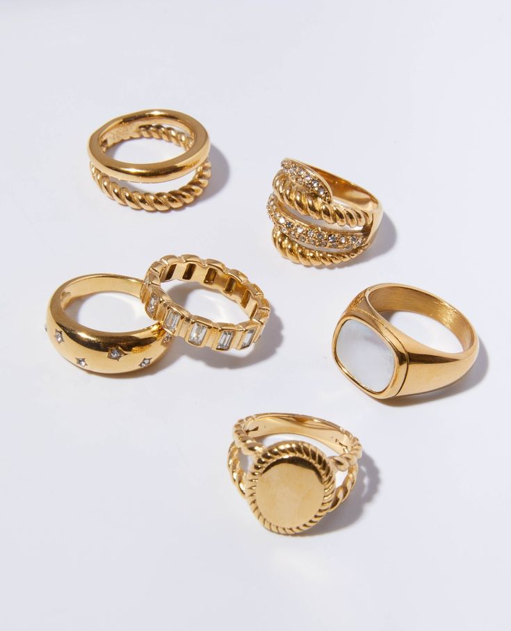 Multiple gold rings showcased on a white table