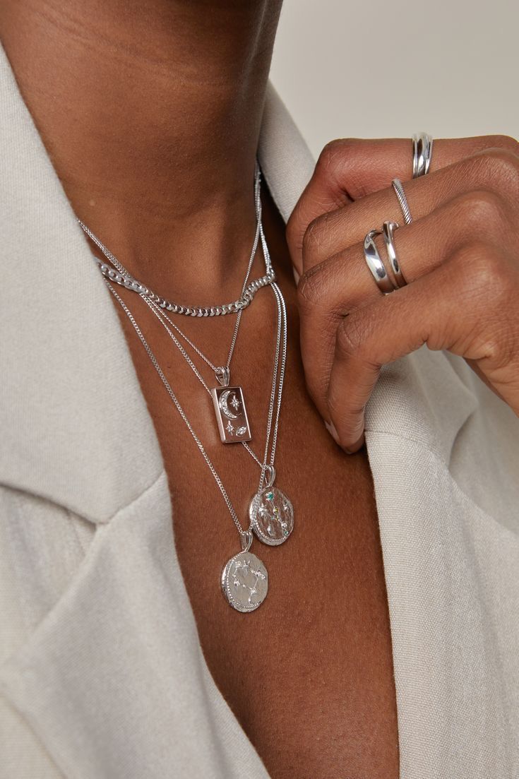 Silver chains worn on neck and silver rings on finger